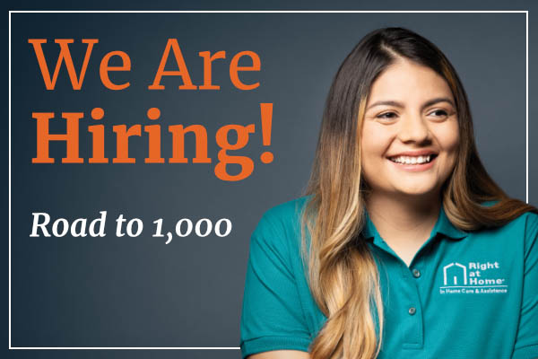 Female Right at Home caregiver smiling next to text that reads "We are hiring" and "Road to 1,000"
